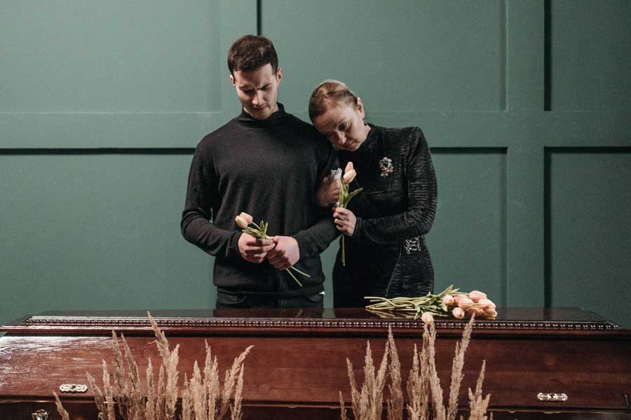 Familie nimmt gemeinsam mit Blumen Abschied